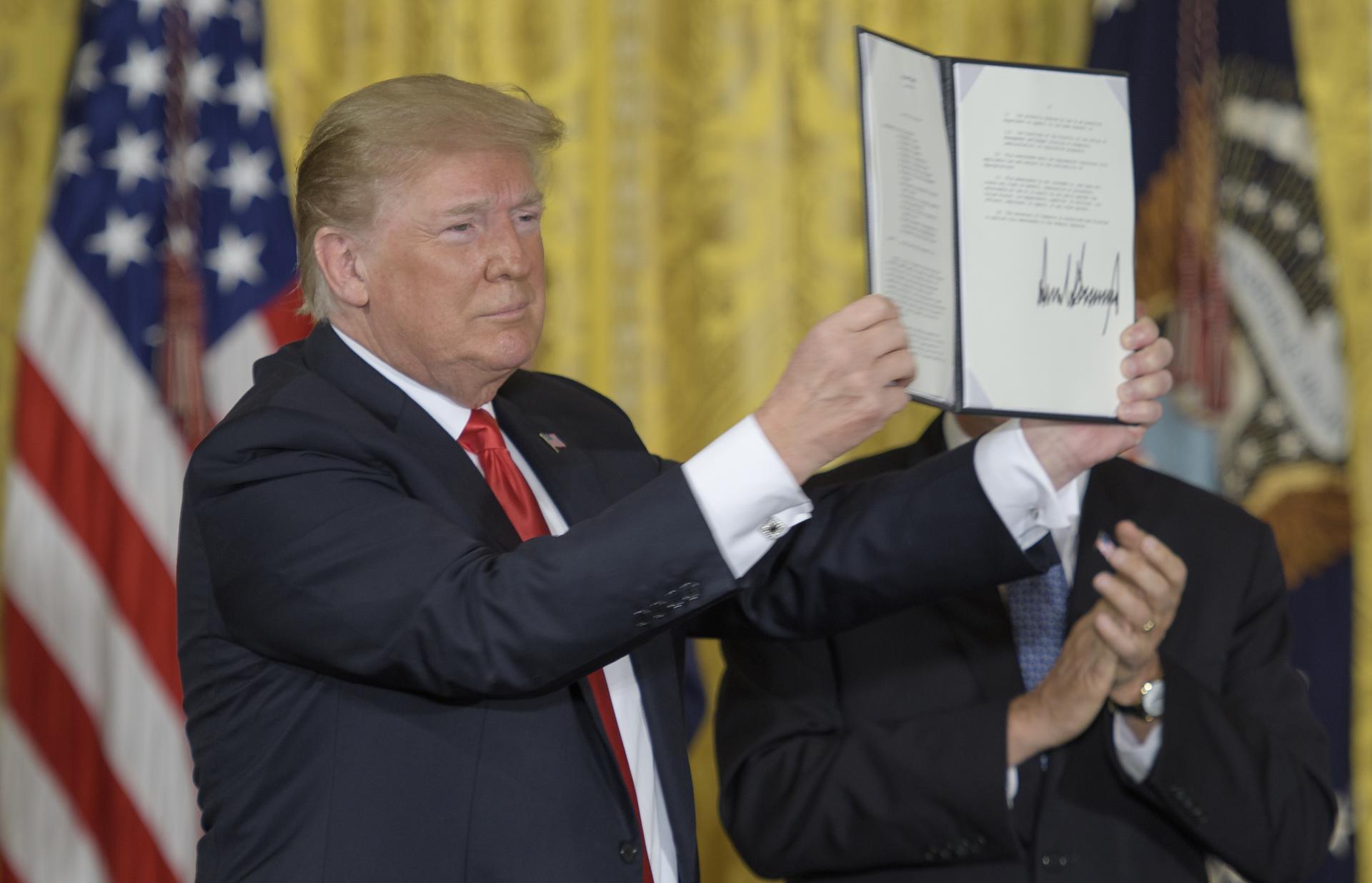President Trump holds up Space Policy Directive-3 at the White House on June 18, 2018; Credits: Wikipedia