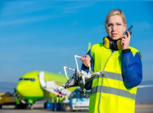 Airport worker holding crashed quadcopter near airliner. Credit Space Foundation