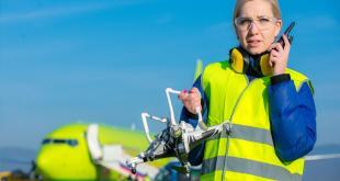 Airport worker holding crashed quadcopter near airliner. Credit Space Foundation