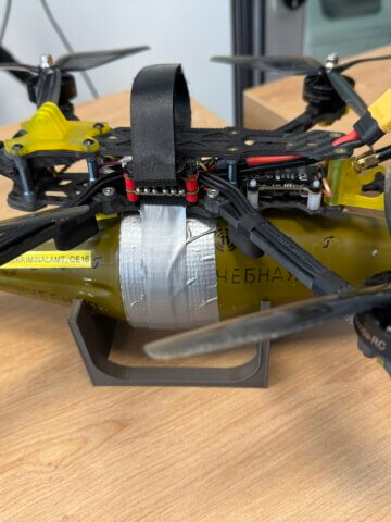 An inert training article on a Bundeskriminalamt display stand at DLR Cochstedt: a racing quadcopter with an anti-tank warhead taped to its underside; Credits:SpaceWatch.Global