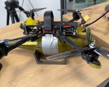 An inert training article on a Bundeskriminalamt display stand at DLR Cochstedt: a racing quadcopter with an anti-tank warhead taped to its underside; Credits:SpaceWatch.Global