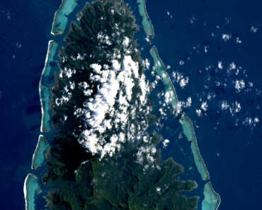 Raiatea, French Polynesia, photographed from the International Space Station: a high volcanic island ringed by its barrier reef and lagoon. Image: ESA/NASA – S. Adenot.